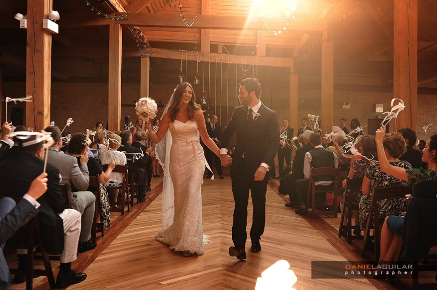 A bride and groom walk down the aisle celebrating after getting married.