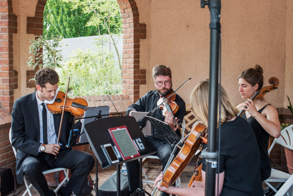 A string quartet plays a custom playlist during a wedding prelude.